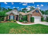 Charming brick home with a well-manicured lawn and inviting landscaping, offering great curb appeal at 24 Willowbend Dr., Murrells Inlet, SC 29576