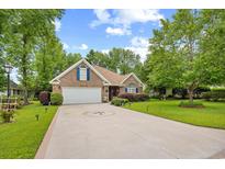 Charming brick home with manicured lawn, two-car garage, and inviting curb appeal at 2636 Brick Dr., Longs, SC 29568