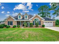 Charming brick home with manicured lawn, attached garage, and beautiful landscaping at 301 Farmtrac Dr., Aynor, SC 29544