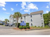 Well-maintained condo building exterior with tidy landscaping, blue signage, and convenient parking at 351 Lake Arrowhead Rd. # 4-114, Myrtle Beach, SC 29572