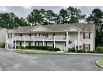Two story condo building with white railings, stairs, and lush landscaping at 3677 Clay Pond Village Ln. # 6, Myrtle Beach, SC 29579
