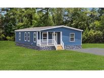 Charming home featuring blue siding, a welcoming front porch, and a well-maintained lawn at 3759 Green Sea Rd., Green Sea, SC 29545