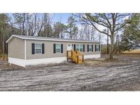 Exterior of a charming single story home with wooden porch and dark shutters at 3768 Green Sea Rd., Green Sea, SC 29545