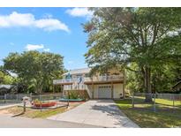 Inviting two-story home with a spacious deck, a white picket fence, and a well-manicured lawn at 3926 Flagg St., Murrells Inlet, SC 29576