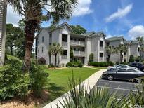 Attractive condo building with large palm trees and well-maintained landscaping and ample parking at 398 Blue Stem Dr. # 59E, Pawleys Island, SC 29585