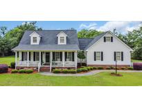 Charming two-story home featuring a welcoming front porch and beautifully landscaped front yard at 412 Carolina Dr., Loris, SC 29569