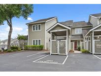 Charming townhouse with dedicated parking and well-maintained landscaping under a bright blue sky at 435 Ocean Creek Dr. # 2722, Myrtle Beach, SC 29572