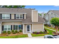 Charming two-story townhome with a landscaped front yard, tan siding, and black shutters at 503 20Th Ave. N # 55B, North Myrtle Beach, SC 29582