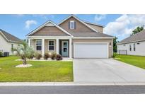 Charming home features a two-car garage, manicured lawn, and beautiful curb appeal at 553 Pier Ct., Longs, SC 29568