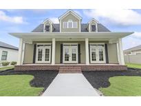 Charming one-story home featuring a brick foundation, gabled windows, and a welcoming front porch at 853 Bluffview Dr., Myrtle Beach, SC 29579