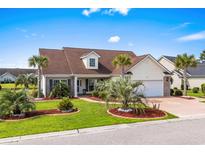 Charming home featuring a lush, landscaped front yard with mature palm trees and a private driveway at 1009 Hopscotch Ln., Conway, SC 29526