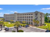 Spacious multi-story condo building with manicured lawns, palm trees, and ample parking at 131 Waypoint Ridge Ave. # Q26, Little River, SC 29566