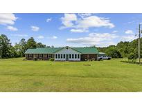 Lovely single story home with a large front yard and green metal roof at 1342 Highway 90, Conway, SC 29526