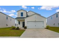 Charming two-story home features a two-car garage, manicured lawn, and classic white siding at 1560 Swing Bridge Way, Myrtle Beach, SC 29588