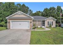 Charming single-story home featuring a two-car garage, manicured lawn, and a cozy screened-in porch entrance at 1904 Ronald Phillips Ave., Conway, SC 29527