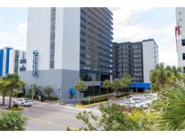 Coastal condominium building with blue accents, palm trees, and well-maintained landscaping at 2001 S Ocean Blvd. # 303, Myrtle Beach, SC 29577