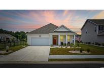 Charming single-story home featuring a well-manicured lawn, inviting porch, and attached garage at 205 Longside Ct., Little River, SC 29566