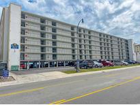 Condominium exterior showing multiple floors with parking and street view under cloudy sky at 2101 S Ocean Blvd. # A-4, North Myrtle Beach, SC 29582