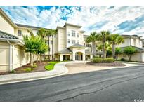 Beautiful building exterior features manicured landscaping, sidewalks, and palm trees against a cloudy sky at 2180 Waterview Dr. # 635, North Myrtle Beach, SC 29582
