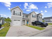Charming townhome featuring gray siding, black shutters, a white garage door, and a blue front door at 238 Christiana Ln. # C, Myrtle Beach, SC 29579