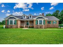 Charming brick home featuring a well-maintained lawn and inviting front porch at 3511 Sumpter Rd., Loris, SC 29569