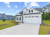 Charming two-story home with a white exterior, a well-manicured lawn and a concrete driveway at 432 Rose Fountain Dr., Myrtle Beach, SC 29579