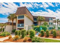 Beautiful exterior of a condo building with palm trees and manicured landscaping on a sunny day at 5601 N Ocean Blvd. # C-314, Myrtle Beach, SC 29577