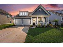 Charming single-Gathering home featuring an inviting front porch, well-manicured lawn, and a two-car garage at 981 Mourning Dove Dr., Myrtle Beach, SC 29577
