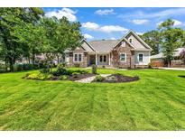 Charming stone-accented home featuring a beautifully landscaped front yard and mature trees at 133 Deloach Trail, Pawleys Island, SC 29585
