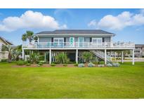 Charming coastal home with a spacious porch, lush landscaping, and a well-manicured lawn at 1705 N Ocean Blvd. N, North Myrtle Beach, SC 29582