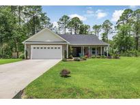 Charming single-story home featuring an attached garage, lush lawn and a welcoming front porch at 173 Crossroad Dr. Nw, Calabash, NC 28467
