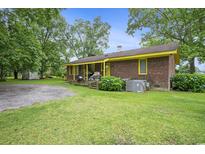 Brick house with yellow trim and a well-maintained lawn at 1731 Lee Ln., Longs, SC 29568