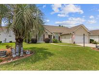 Charming, single-story home with a well-manicured lawn and mature landscaping including a palm tree at 1776 Starbridge Dr., Surfside Beach, SC 29575