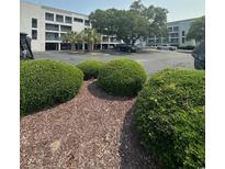 Building exterior with landscaping in front of building and parking lot at 201 Hillside Dr. N # 111, North Myrtle Beach, SC 29582