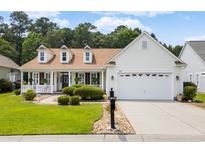 Charming home with manicured lawn, front porch with rocking chairs, and a two-car garage at 29 Saltwind Loop, Murrells Inlet, SC 29576