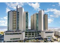 Stunning resort exterior with ocean view, bright blue sky, and lush tropical landscaping at 300 N Ocean Blvd. # 723, North Myrtle Beach, SC 29582
