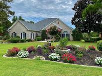 Well-maintained home with lovely curb appeal, manicured lawn and a colorful flower bed in front at 383 Oatland Lake Rd., Pawleys Island, SC 29585