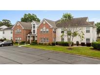 Inviting two-story condo with brick accents, lush landscaping, and well-maintained lawn at 4387 Daphne Ln. # B, Murrells Inlet, SC 29576