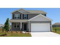 Charming two-story home featuring a neutral color scheme, a two-car garage, and a well-manicured front yard at 5180 Yellowstone Dr., Conway, SC 29526