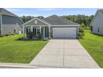 Charming single-story home featuring a well-manicured lawn and a two-car garage at 519 Royal Jay Ln., Longs, SC 29568