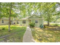 Charming single-story home with a well-maintained lawn, mature trees, and a welcoming walkway at 6610 Mallard View Point, Myrtle Beach, SC 29588