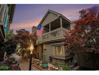 Charming home featuring a covered balcony, beautiful landscaping, and an American flag at 705 11Th Ave. S, North Myrtle Beach, SC 29582
