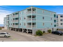 Three story condo building with light blue painted exterior walls, white trim, and multiple balconies for each unit at 824 N Waccamaw Dr. # 203, Murrells Inlet, SC 29576