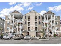 Three-story condo building featuring a beige exterior and white pillars, with parking available in front at 149 Ella Kinley Circle # 302, Myrtle Beach, SC 29588