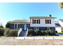 Charming two-story home with light blue door, white trim, and well-manicured landscaping at 1931 Lakeview Circle, Surfside Beach, SC 29575