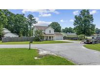 Charming two-story home featuring a well-manicured lawn, attached garage, and a welcoming covered front porch at 216 Deer Trace Circle, Myrtle Beach, SC 29588