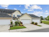 Charming townhome with attached garage and landscaped front yard on a sunny day at 2504 Heritage Loop # 2504, Myrtle Beach, SC 29577