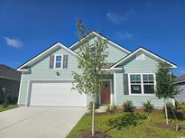 Charming single-Gathering home with light blue siding, white garage door, and manicured lawn at 2855 Riverboat Way, Conway, SC 29526