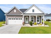 Charming single-story home featuring a manicured lawn, covered porch, and a two-car garage at 314 Bumble Circle, Murrells Inlet, SC 29576
