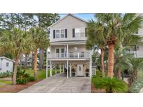 Charming two-story beach house on stilts with palm trees and a well-maintained yard at 327 A Lakeside Dr., Surfside Beach, SC 29575